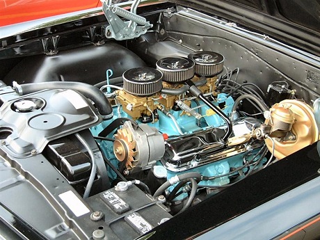 three carburetors in a row topped with three small chrome air filters Pontiac GTO history